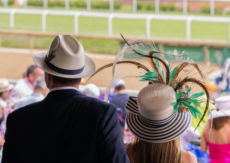Racegoers dress in smart summer attire at the Newmarket July Festival, where the Premier Enclosure encourages elegant outfits.