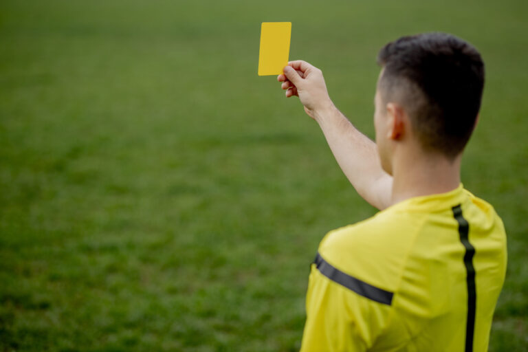 Image of a football referee showing a yellow card